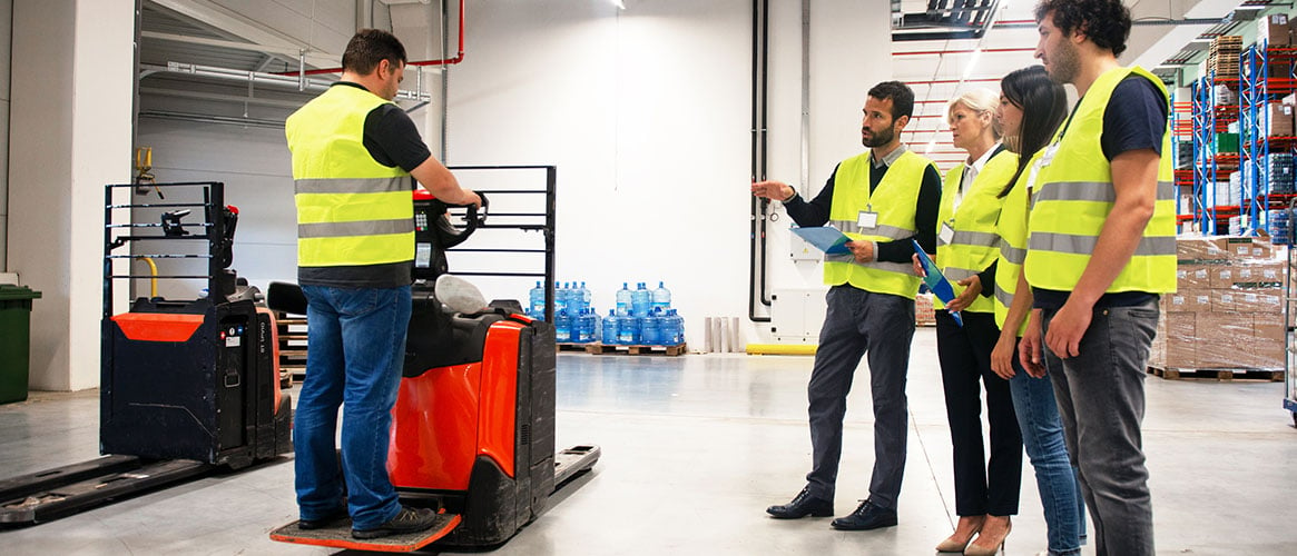 Manager conducting forklift training with employees
