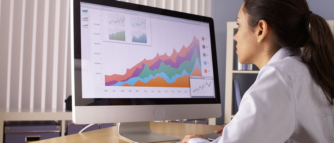 Analyst staring intently at screen full of charts and graphs